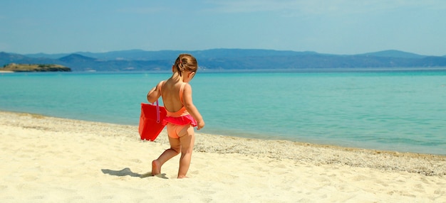 Niño pequeño juega en la orilla del mar de playa