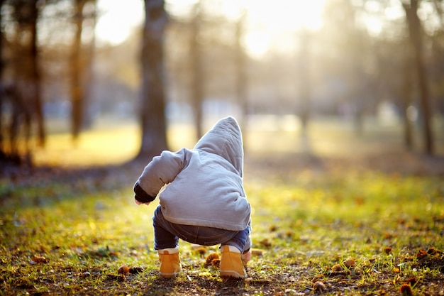 Niño pequeño jugando al aire libre en el cálido día de primavera