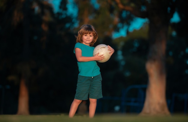 Niño pequeño jugando al fútbol en el campo con una pelota de fútbol concepto de niños deporte pelota activa