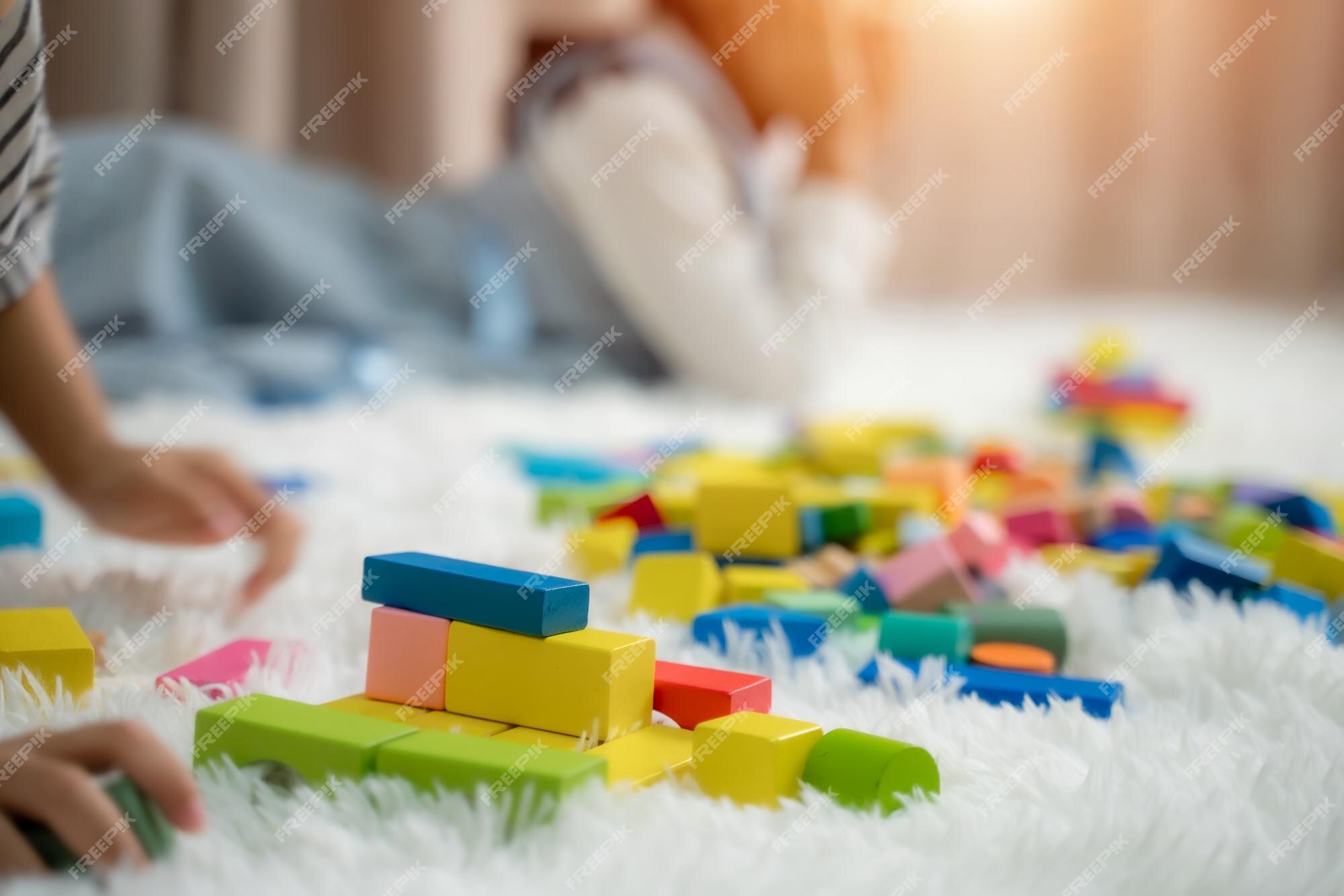 Un niño pequeño está jugando a apilar bloques de lindo juego infantil con juguetes colores. juguetes educativos para niños. | Foto Premium