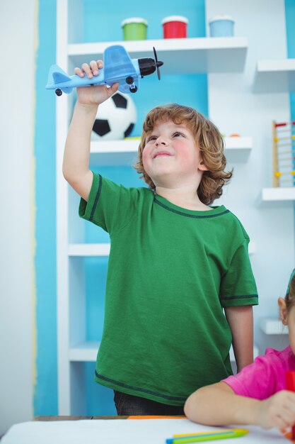 Niño pequeño jugando con un avión de juguete