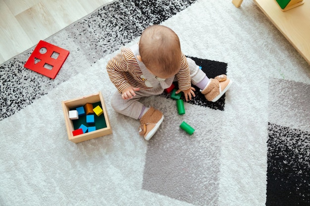 Niño pequeño jugando con la caja de formas montessori Imbucare