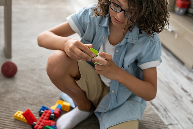 Niño pequeño jugando con coloridos bloques de plástico en casa construyendo imaginación de juegos creativos