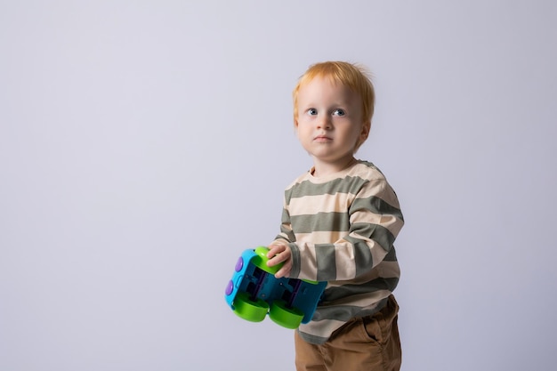 niño pequeño jugando con una máquina de escribir en un fondo blanco