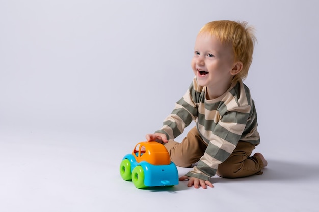 Foto niño pequeño jugando con una máquina de escribir en un fondo blanco