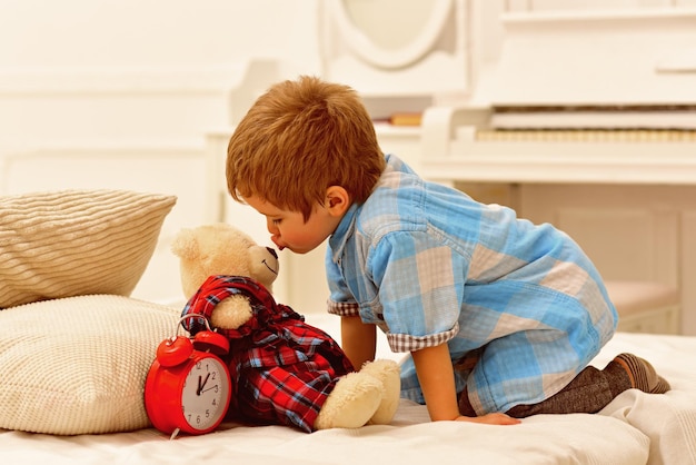 Foto niño pequeño jugando con oso infancia feliz cuidado y desarrollo niño pequeño juega en casa familia feliz y día de los niños juguetes para niños al estilo mejores amigos licencia paterna