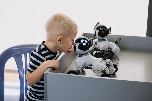 Foto niño pequeño jugando con un robot de control remoto interactivo perro juguete niño y robot de baile inteligente