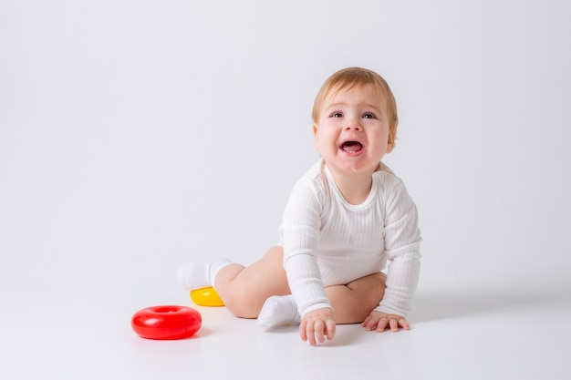 Niño pequeño con juguete sobre fondo blanco.