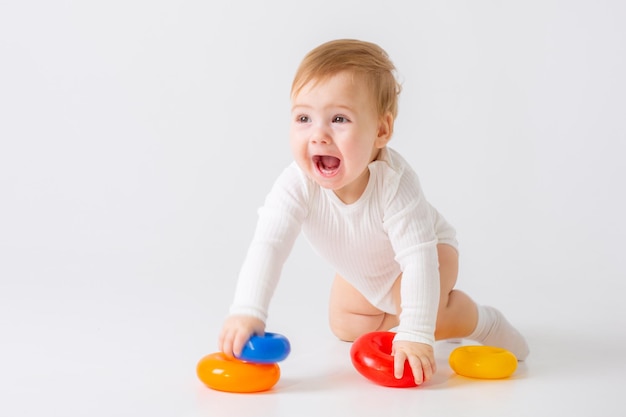 Niño pequeño con juguete sobre fondo blanco.