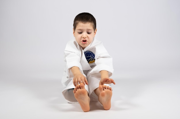 Un niño pequeño en kimono haciendo karate