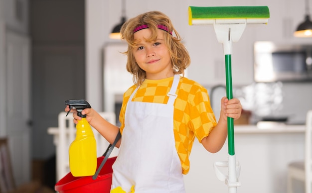 Niño pequeño limpiando en casa Niño haciendo tareas domésticas divirtiéndose Retrato de niño ama de llaves con un trapeador plano mojado en el fondo interior de la cocina