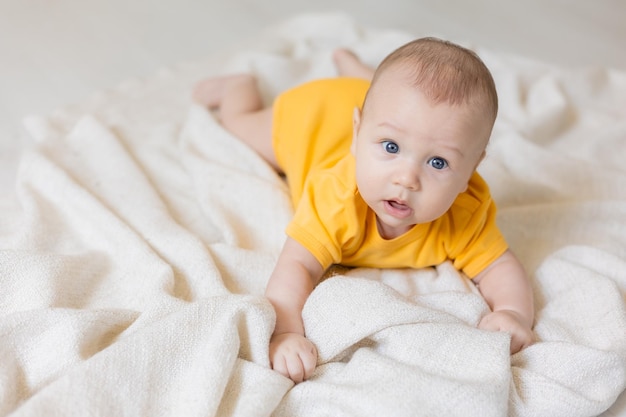 niño pequeño y lindo con cuerpo amarillo tendido sobre una manta, tarjeta, pancarta, salud, espacio para texto