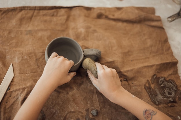 Un niño pequeño y lindo jugando con plastilina en un taller de cerámica, artesanía y arte en arcilla, actividades creativas para niños, educación en artes