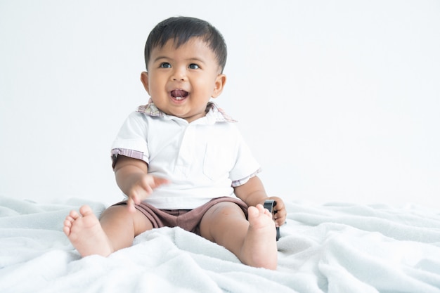 Niño pequeño lindo sentado y sonrisa