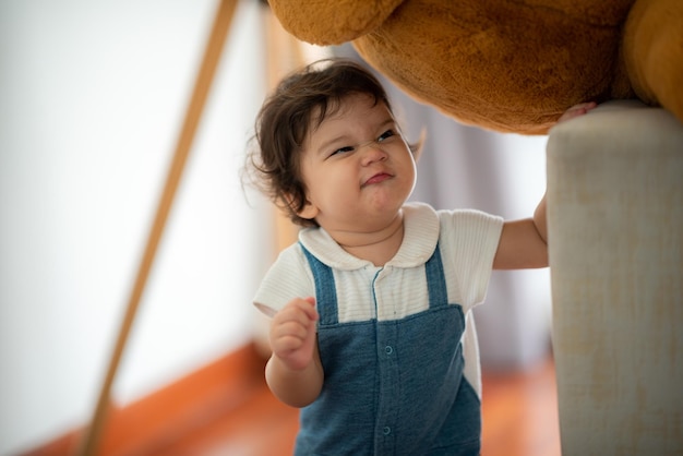 Un niño pequeño y lindo sosteniendo un juguete mientras está sentado en el suelo con un juguete jugando con su padre en casa