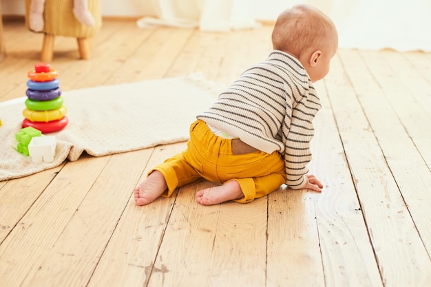 Un niño pequeño y lindo en el suelo de su habitación