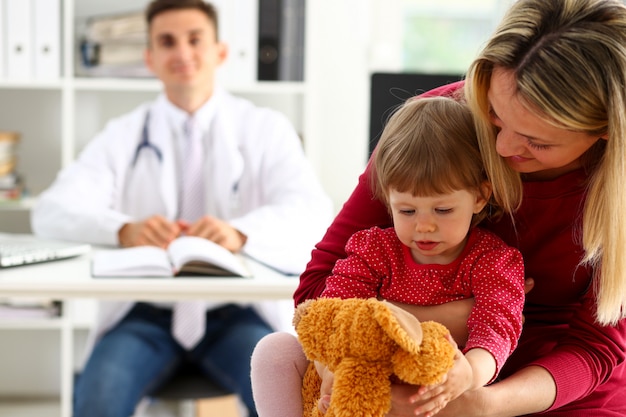 Niño pequeño con madre en la recepción del pediatra