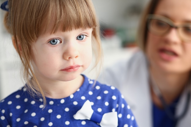 Niño pequeño con madre en la recepción del pediatra