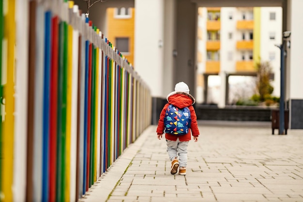 Un niño pequeño con una mochila que va al preescolar.