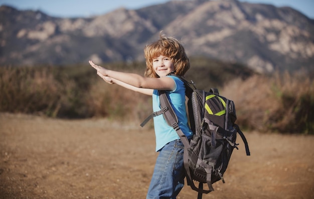 Niño pequeño con mochila de senderismo en montañas escénicas niño turista local va de excursión local