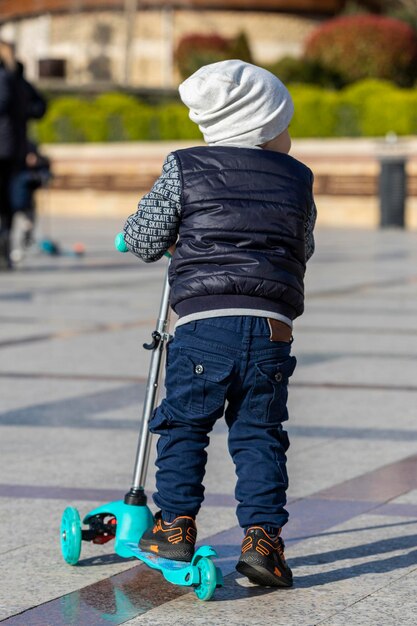 Niño pequeño montando skate en la calle Foto de alta calidad