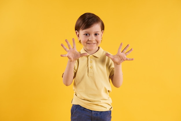 El niño pequeño muestra las palmas de las manos.