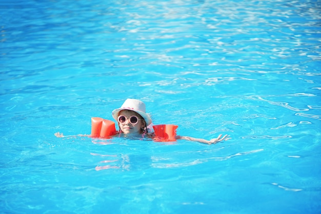 Niño pequeño nadando en la piscina