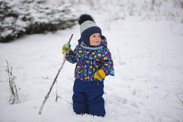 Niño pequeño en la nieve del invierno.