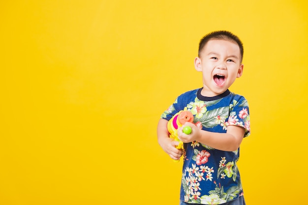 Niño pequeño niño en el día del festival Songkran con pistola de agua