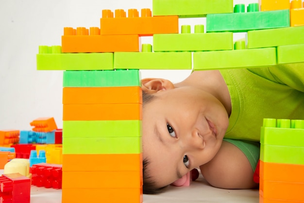 Niño pequeño niño que juega el bloque de ladrillo plástico colorido con feliz