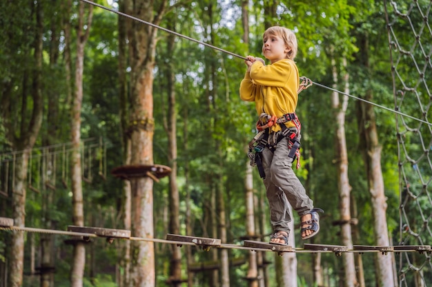 Niño pequeño en un parque de cuerdas Recreación física activa del niño al aire libre en el parque Entrenamiento para niños