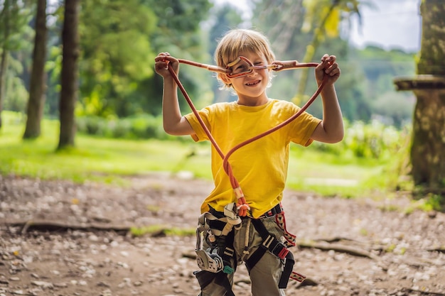 Niño pequeño en un parque de cuerdas Recreación física activa del niño al aire libre en el parque Entrenamiento para niños