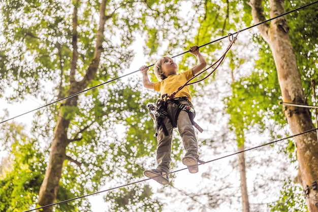 Niño pequeño en un parque de cuerdas Recreación física activa del niño al aire libre en el parque Entrenamiento para niños