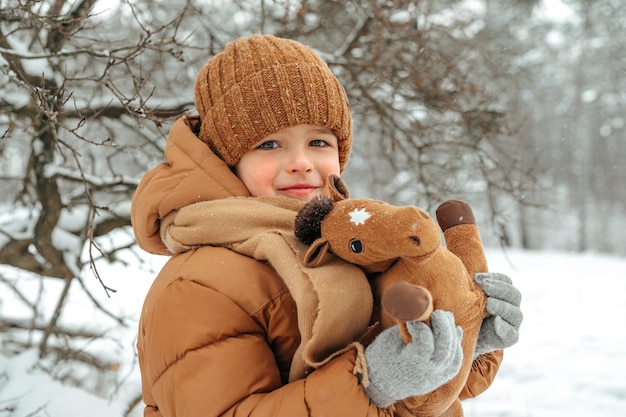 Niño pequeño en un parque o bosque de invierno