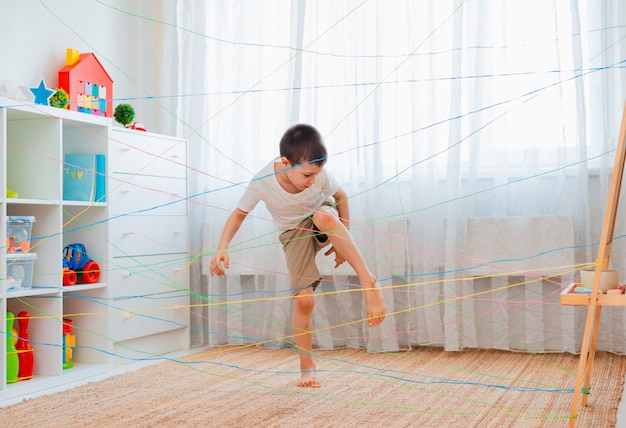 Niño pequeño pasando por una red de cuerda