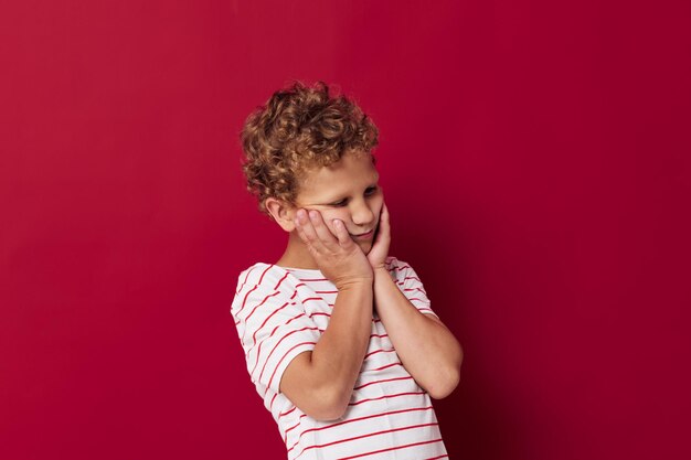 Niño pequeño con pelo rizado posando fondo aislado