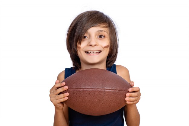 Niño pequeño con la pelota de fútbol americano.