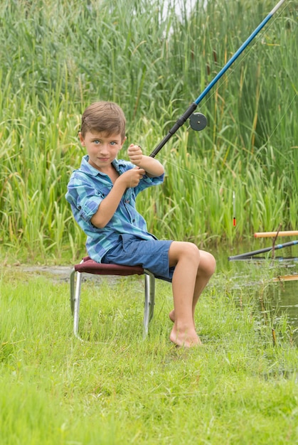 Foto niño pequeño está pescando en el río