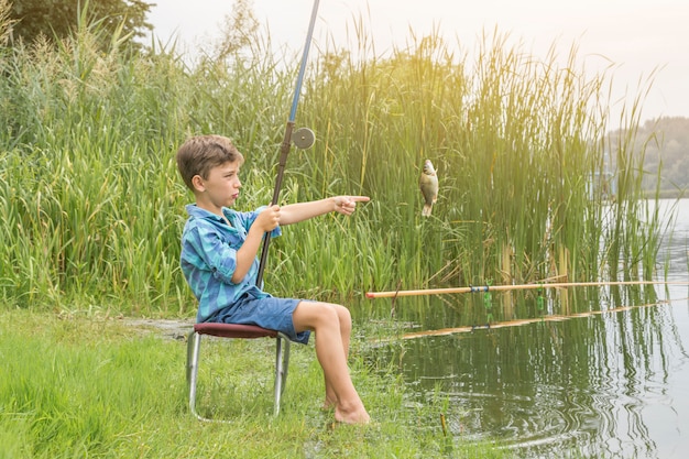 Foto niño pequeño está pescando en el río