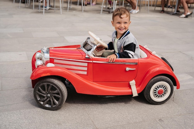 Un niño pequeño posa en un mini coche de carreras Juega y relájate al aire libre