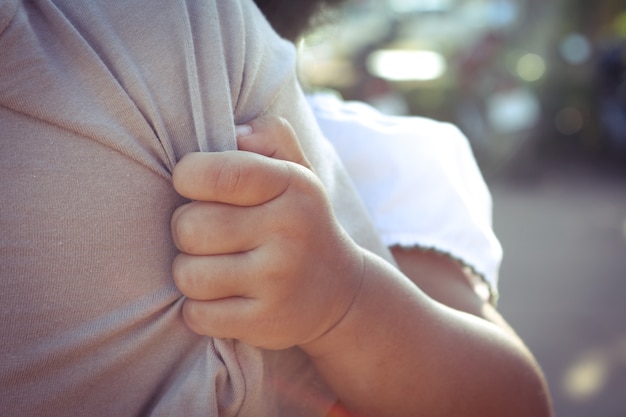 Un niño pequeño que abraza a su madre en el fondo borroso suave, amor del concepto de familia