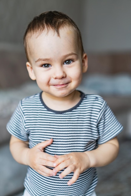 Un niño pequeño que está de pie con una sonrisa en la cara