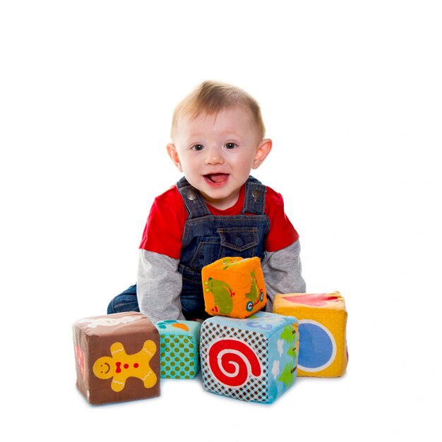 Niño pequeño que juega con el cubo suave coloreado