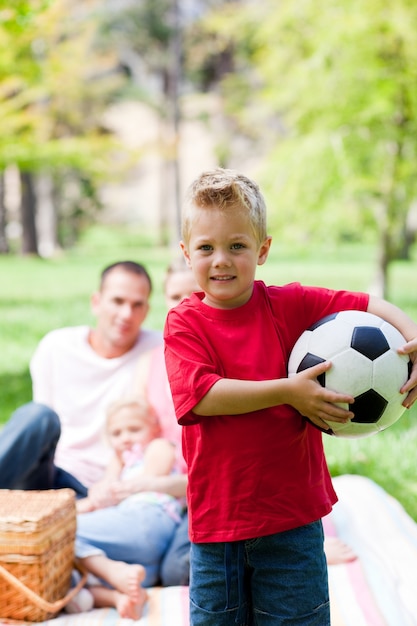 Niño pequeño que sostiene un balón de fútbol