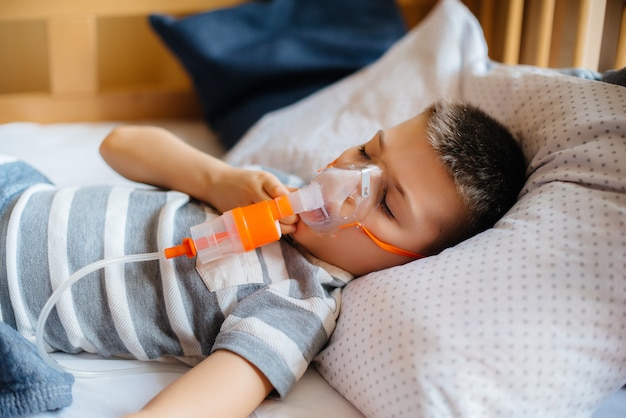 un niño pequeño recibe una inhalación durante una enfermedad pulmonar. Medicina y cuidado