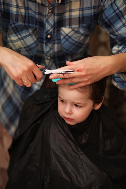 Foto un niño pequeño está recortado en las brillantes emociones del peluquero en su rostro.