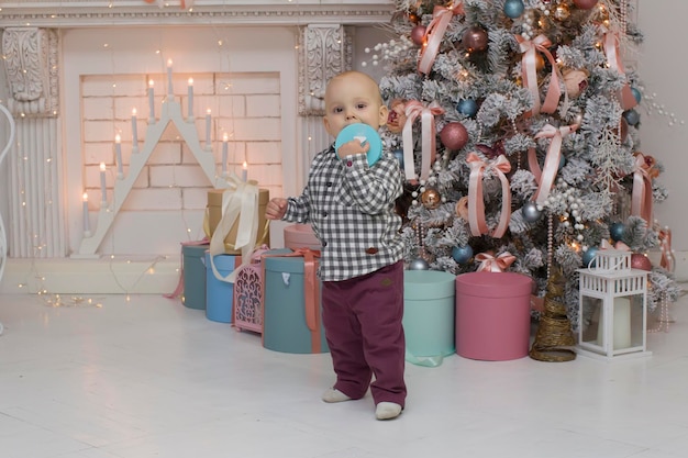 Niño pequeño con un regalo en las manos en el interior de Año Nuevo