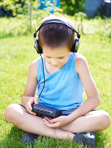 Niño pequeño con reproductor de casetes de audio y auriculares