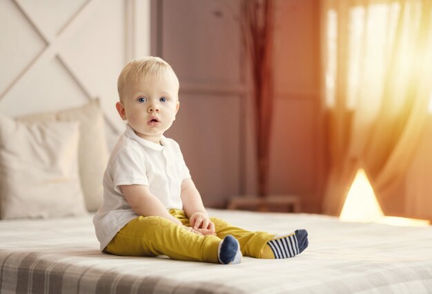 niño pequeño sentado en la cama