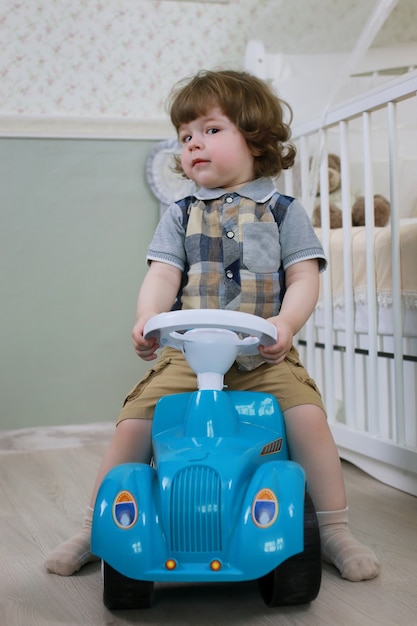 Niño pequeño sentado en un coche de juguete